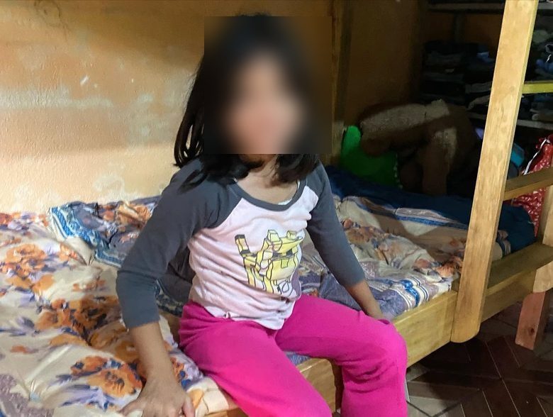 A child smiling on her new bed in Guatemala