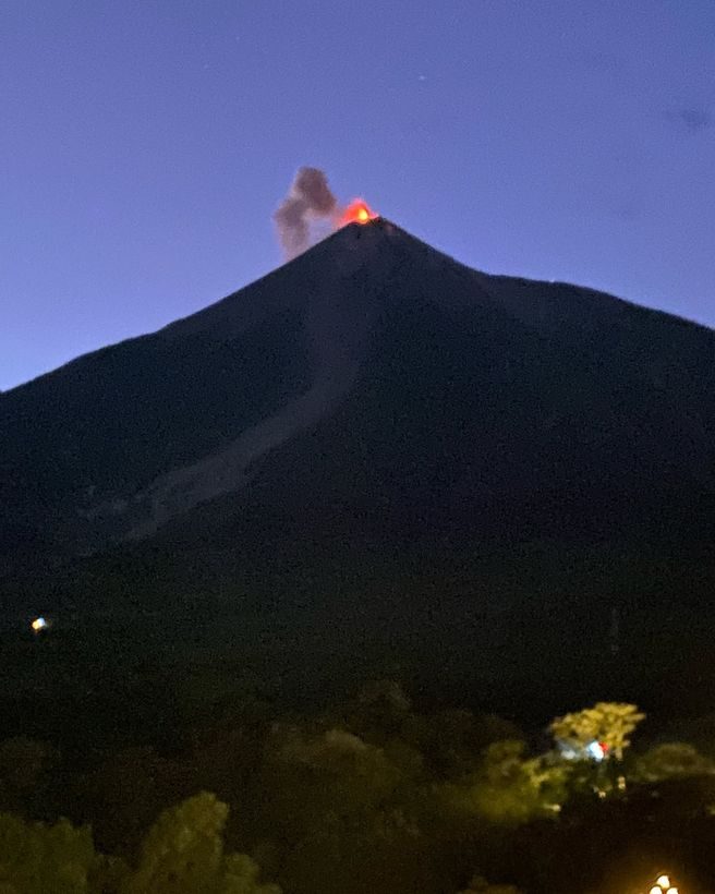 Volcan de Fuego erupting at dusk above the highlands