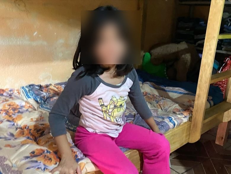 A young girl smiling on her new bed