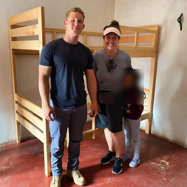 A volunteer with a family's new bunk bed