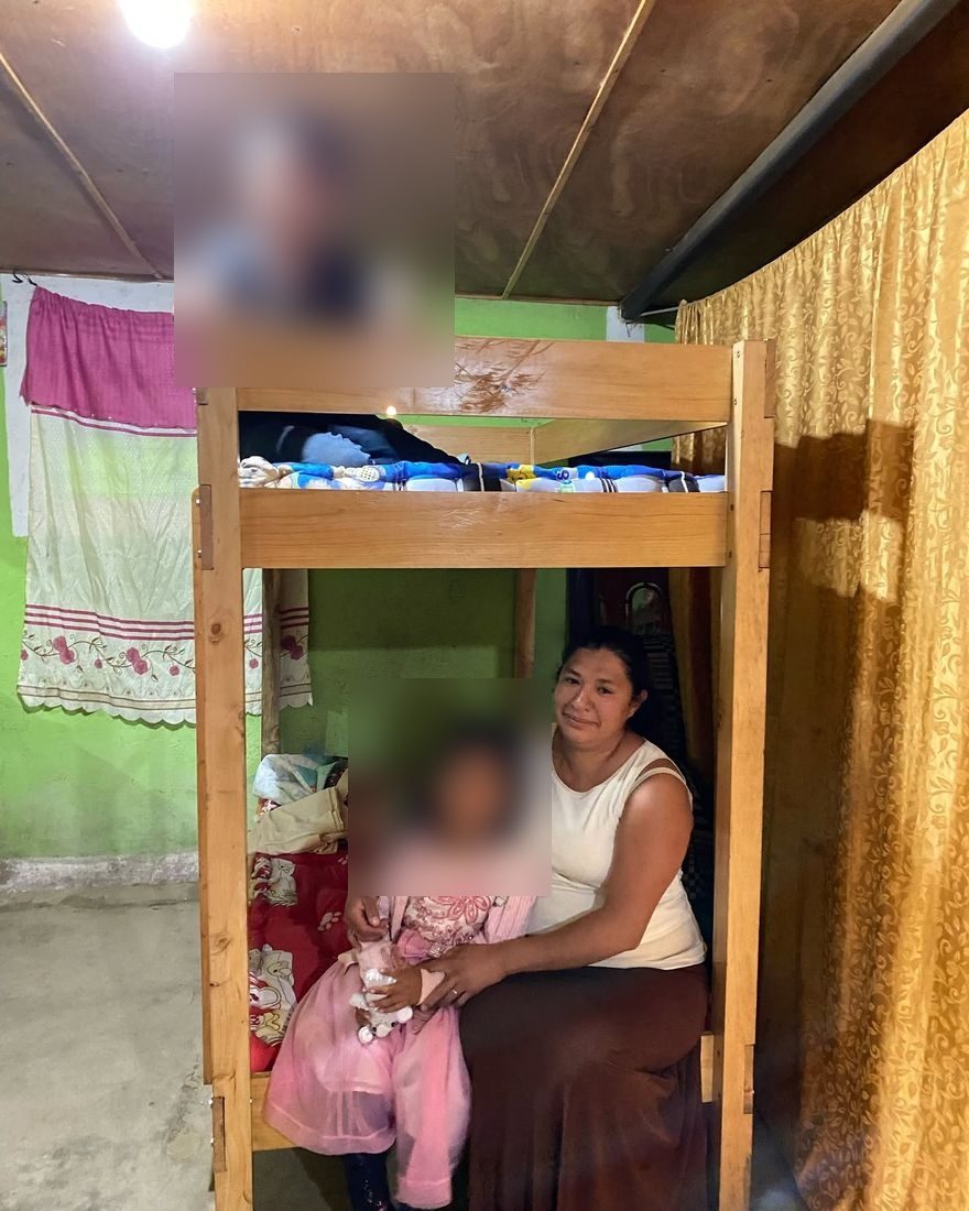 A mother and her two children with their new bunk bed in Guatemala
