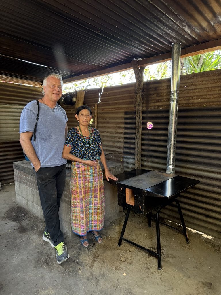 Brad with a family beside their new vented cookstove